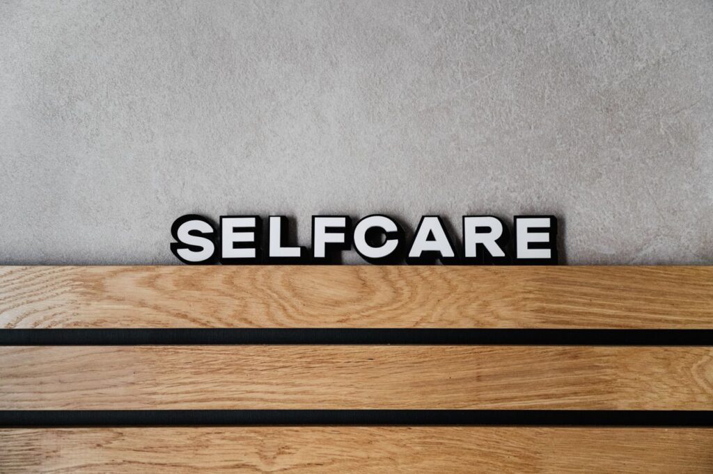 Inspirational 'Selfcare' text on a modern wooden and concrete background emphasizing wellness and lifestyle.